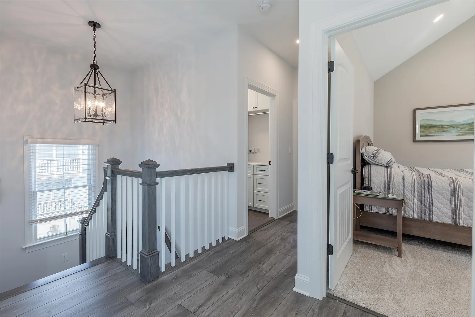 Upstairs hallway with staircase and bedroom.