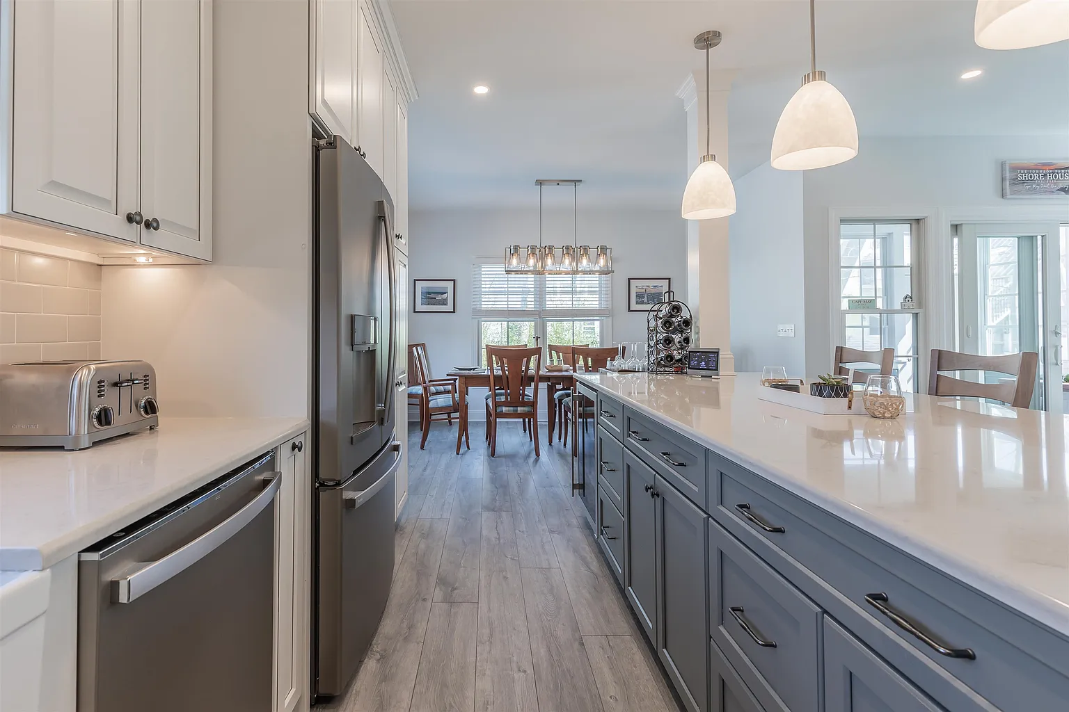 Modern kitchen with gray island and white cabinets.