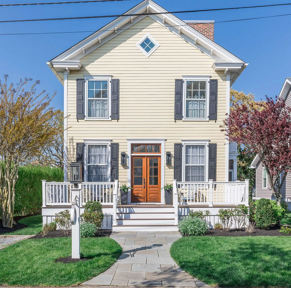 Yellow house with porch and double doors.