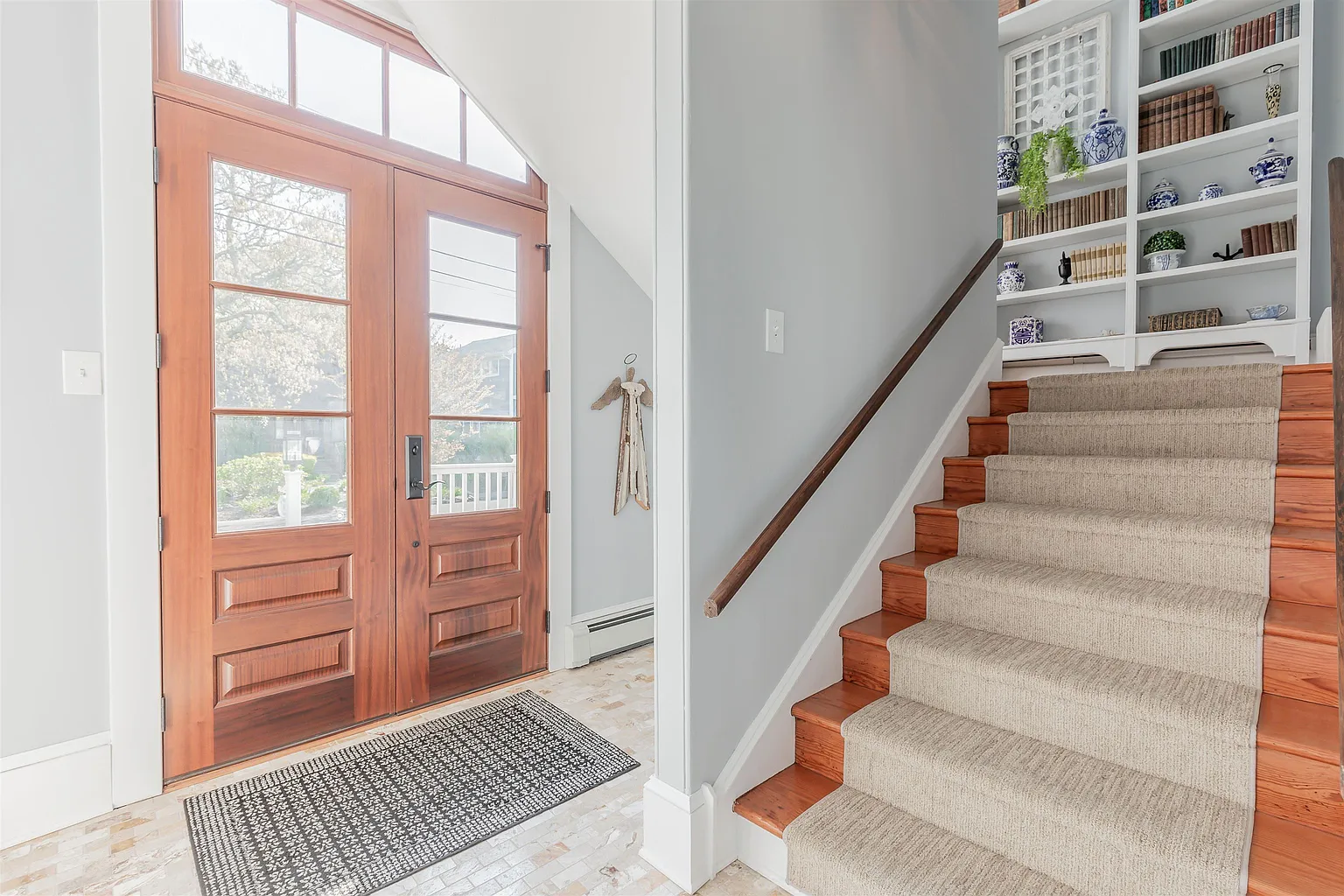 Wooden double doors, staircase, bookshelves.