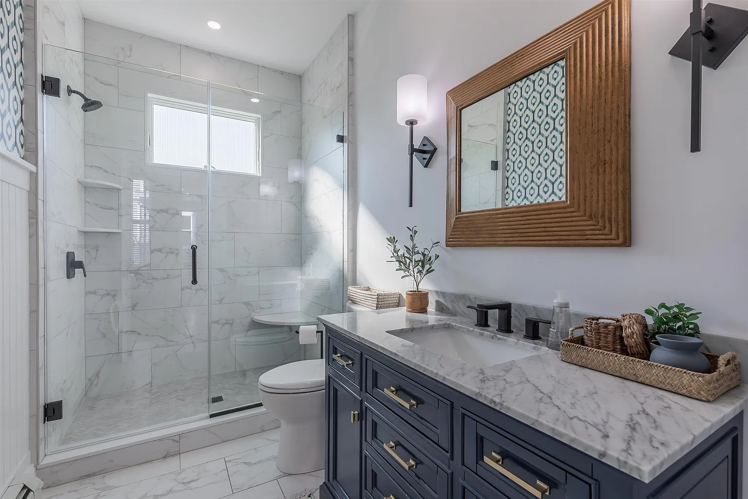Modern bathroom with marble and navy vanity.