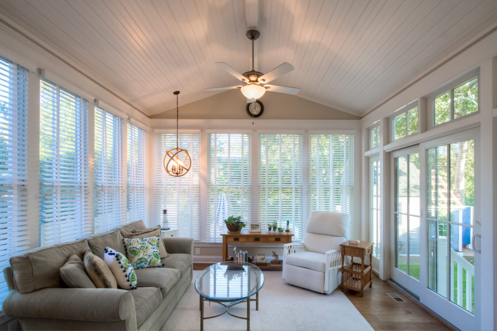 Sunroom with sofa, chair, and windows.