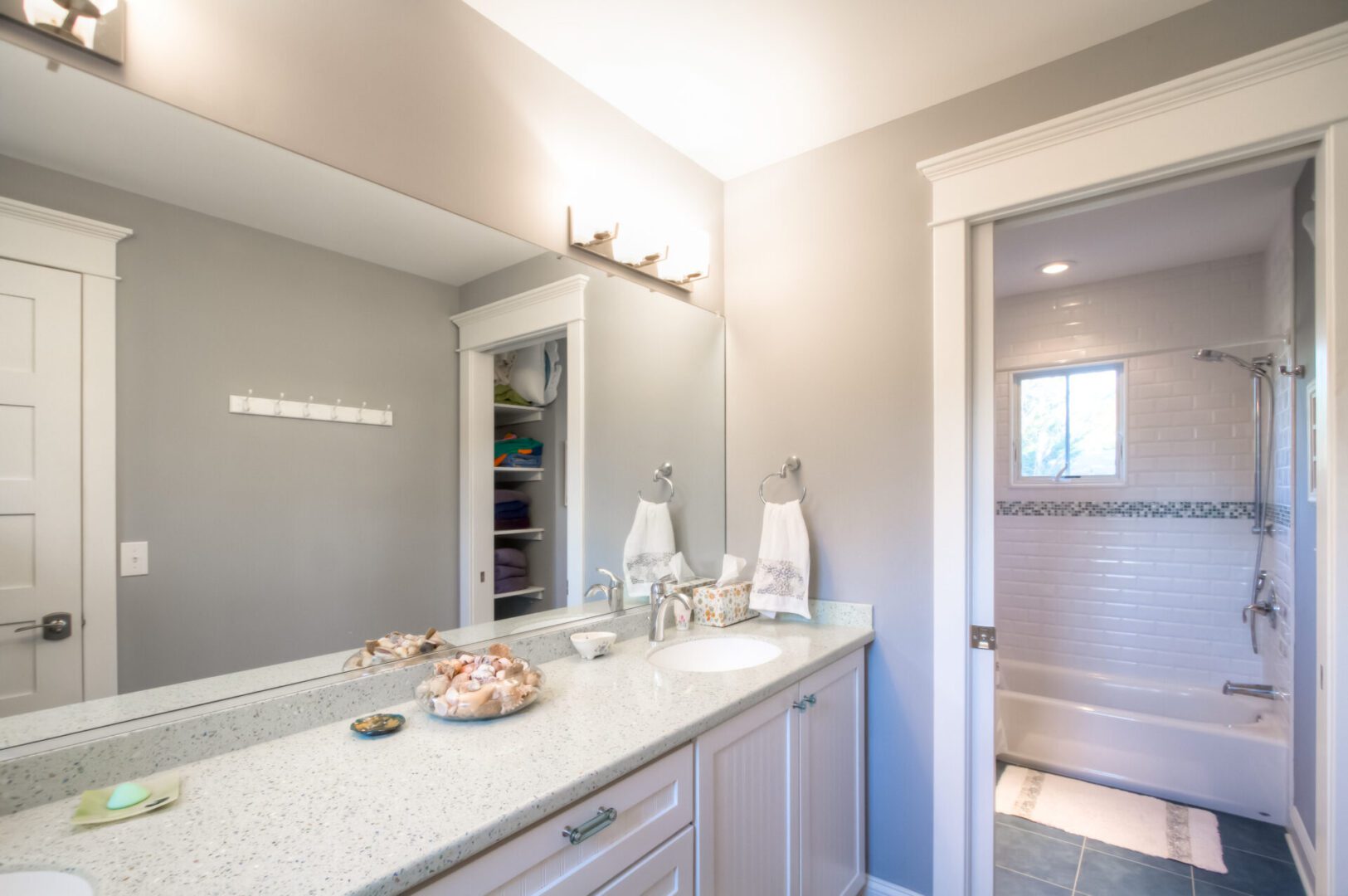 Bathroom vanity with seashells and a shower.