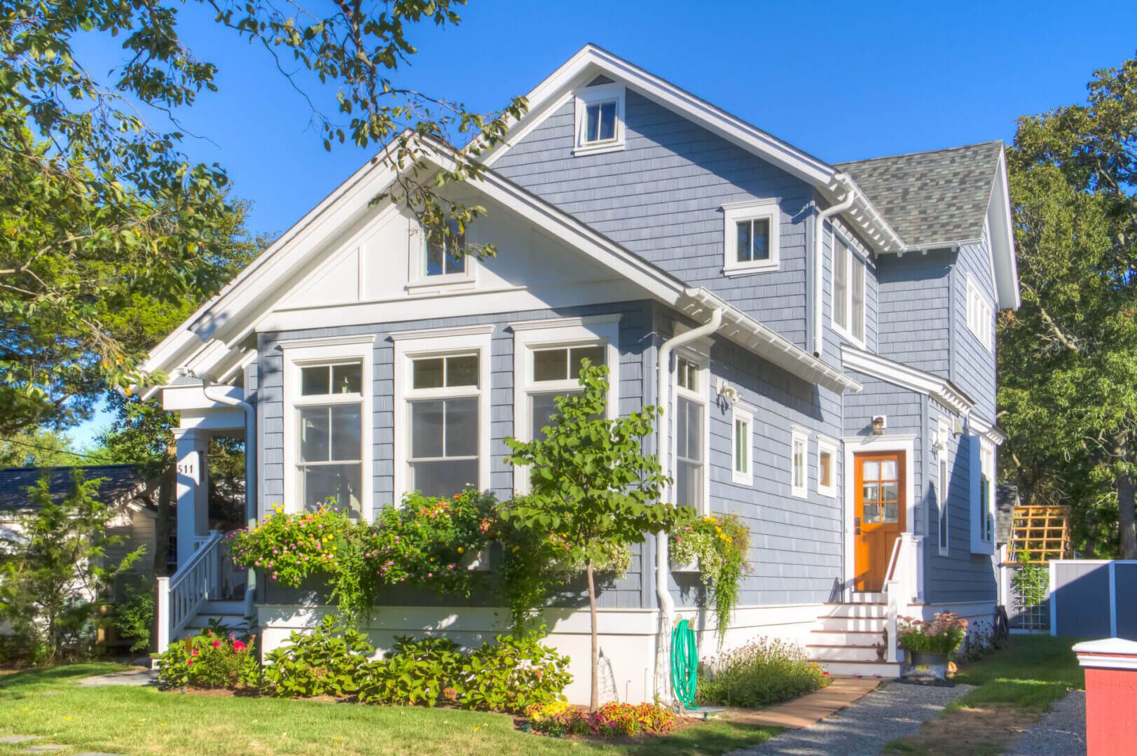 Gray house with flower boxes and garden.