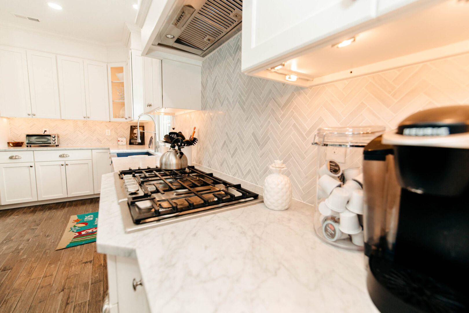 Modern kitchen with marble countertops and gas stove.