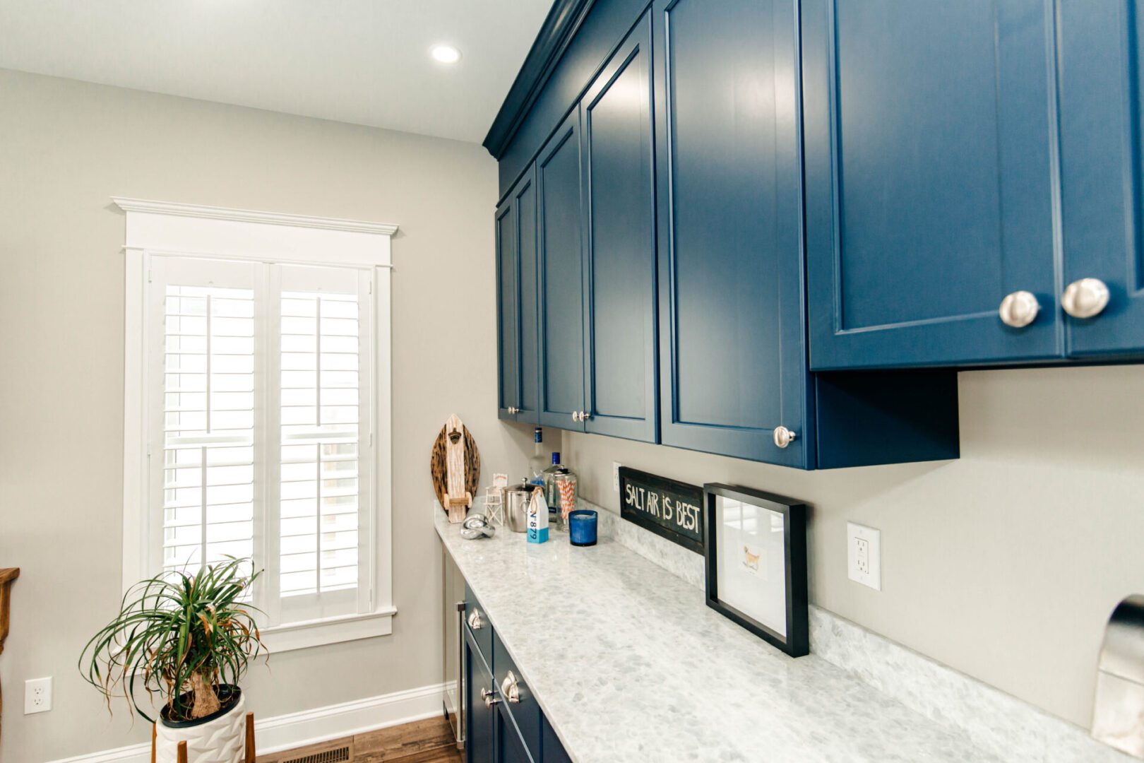 Navy blue kitchen cabinets, white counter.