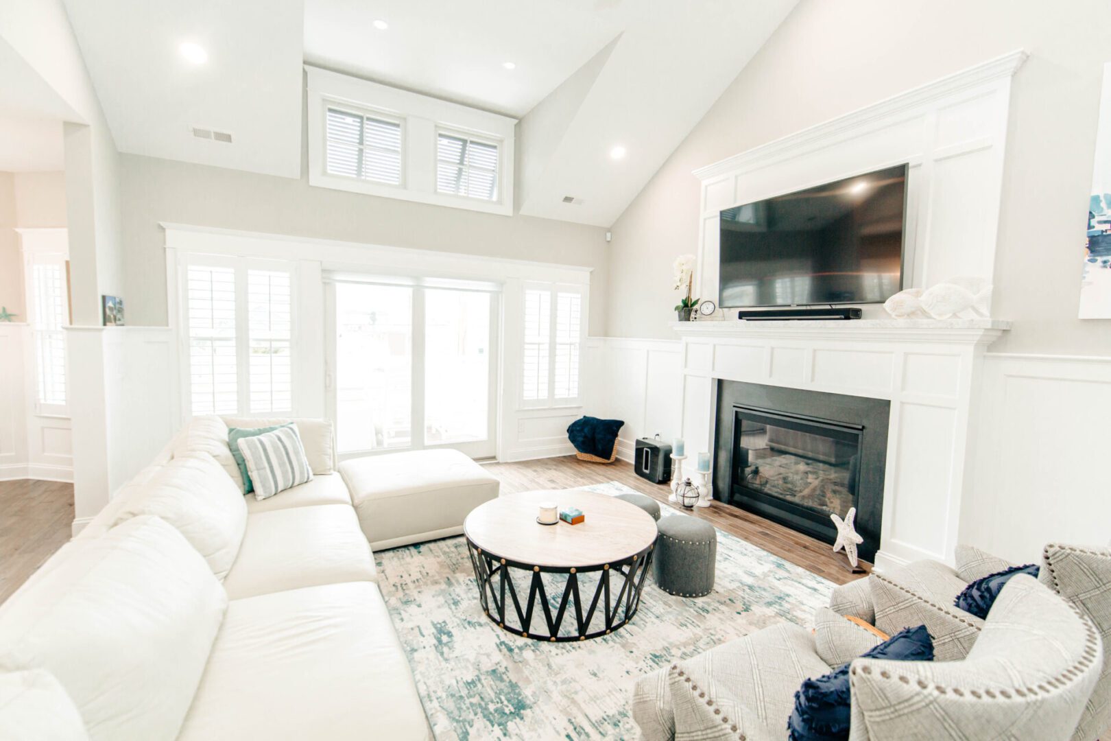 Bright living room with white sofa and fireplace.