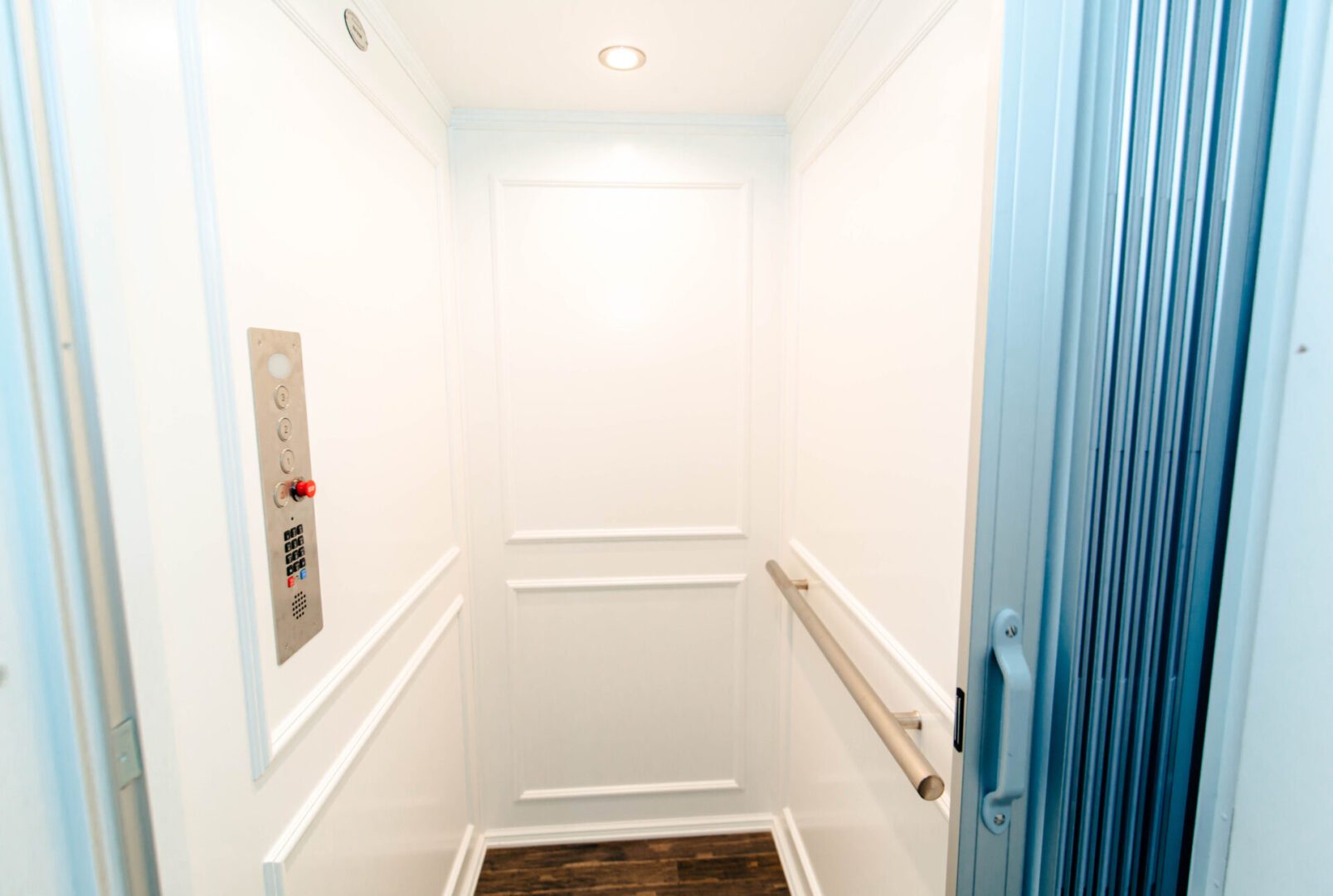 Empty white elevator with blue doors.
