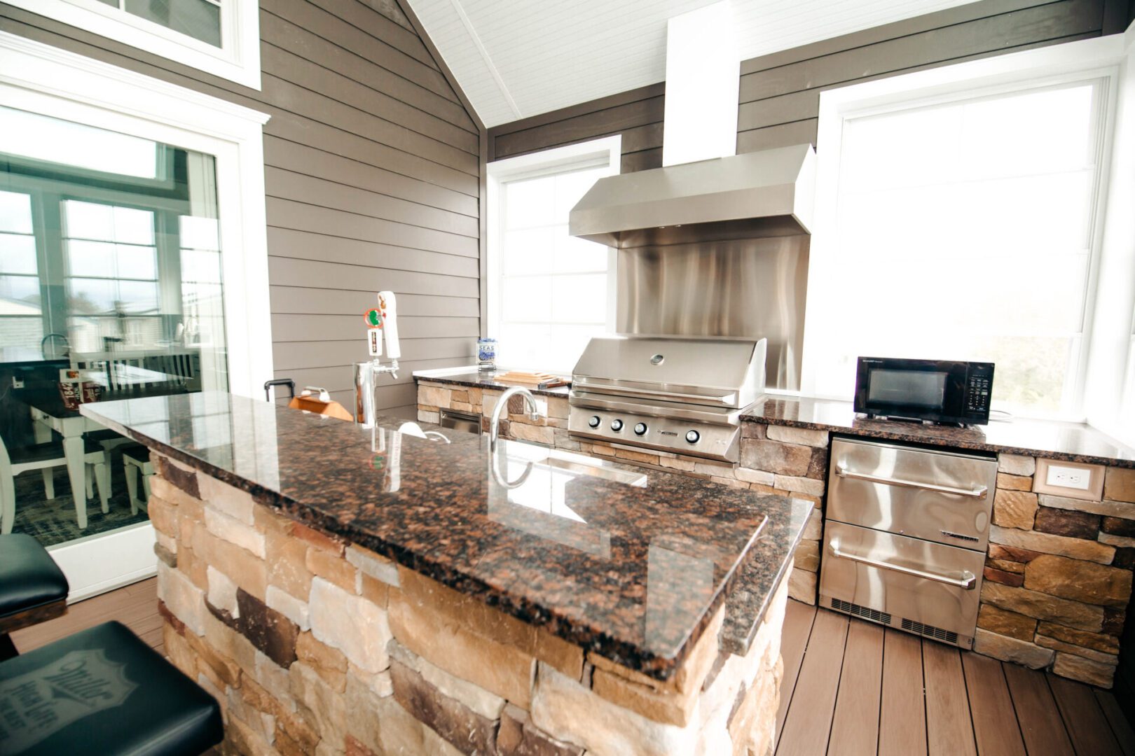 Outdoor kitchen with granite countertop and grill.