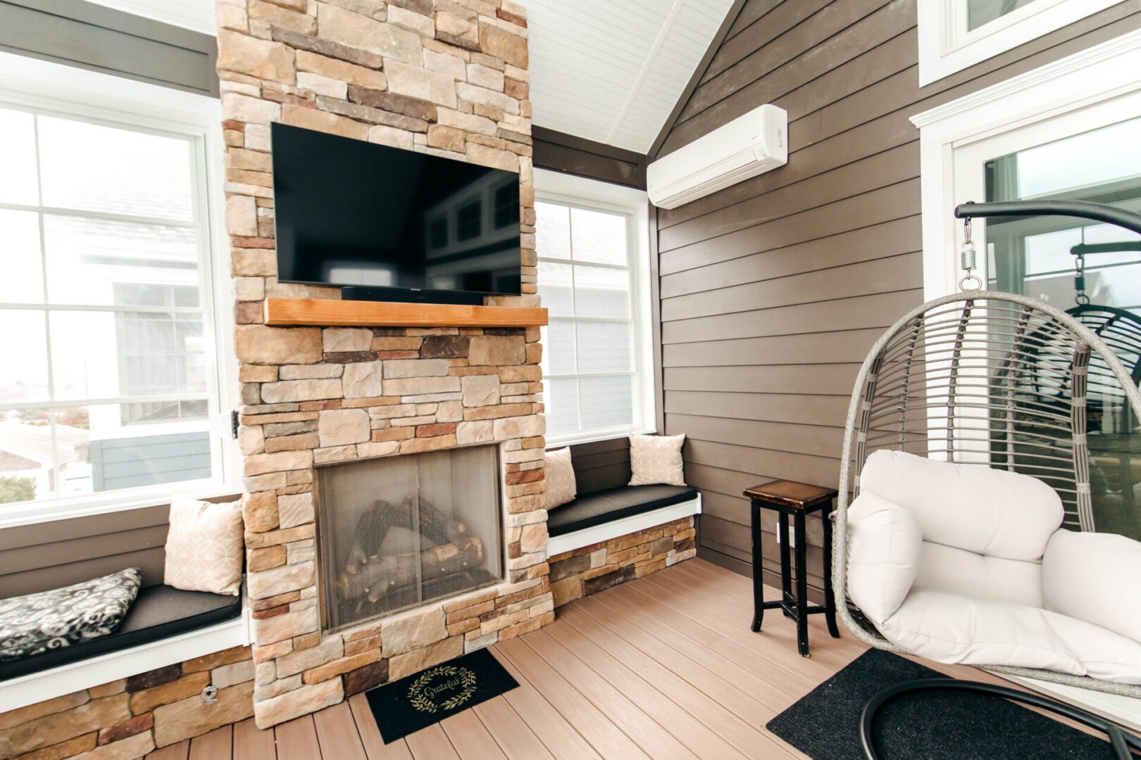 Cozy sunroom with fireplace and swing chair.