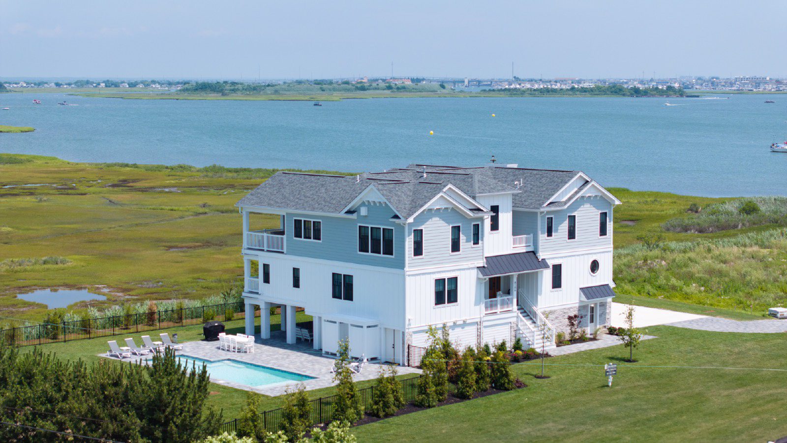 Waterfront home with pool and patio.