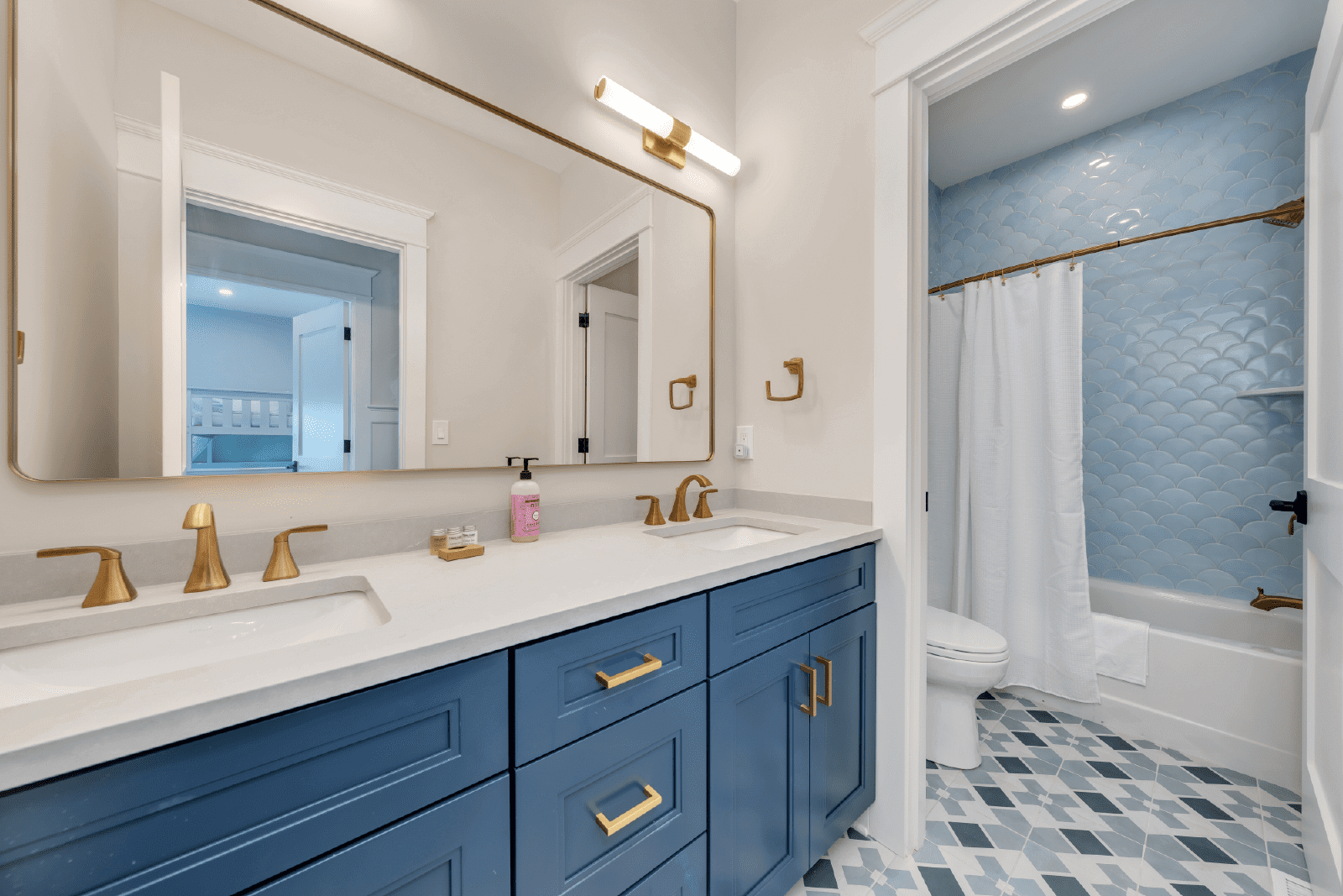 Blue bathroom with gold fixtures and vanity.