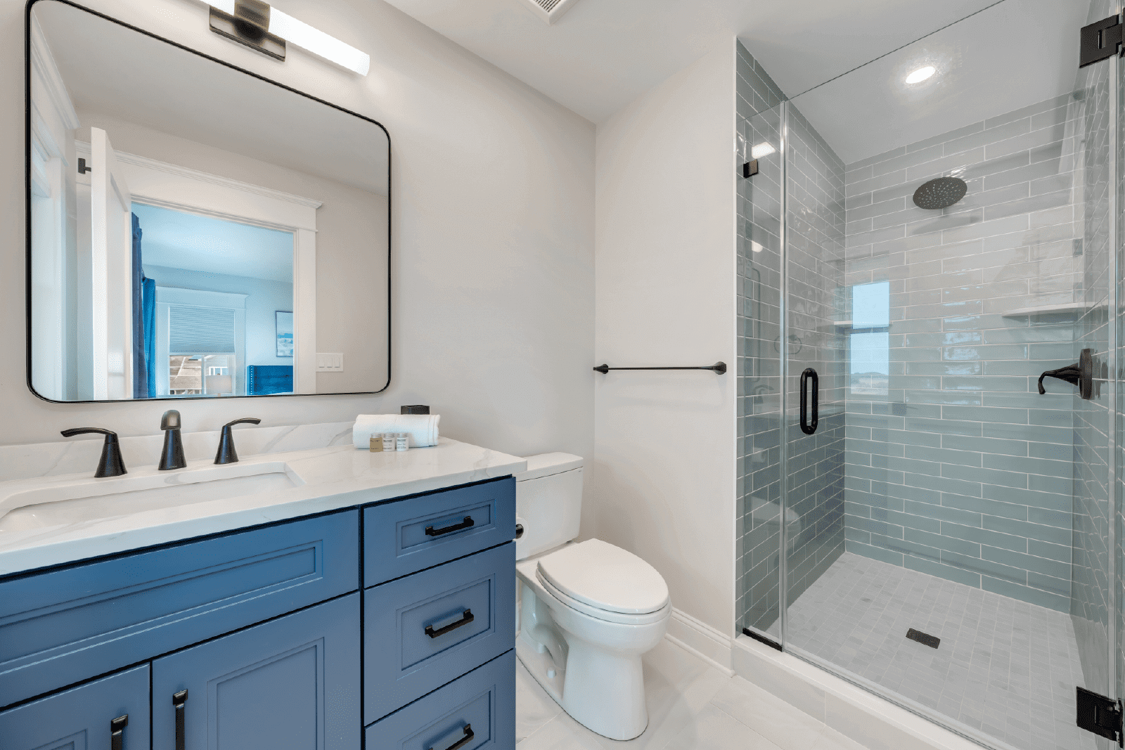 Modern blue bathroom with glass shower.